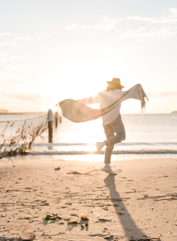 person in white sport shirt on shore during golden hour